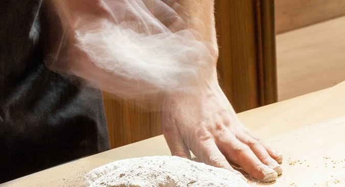 Hands kneading dough to make our PITTABUNS bread