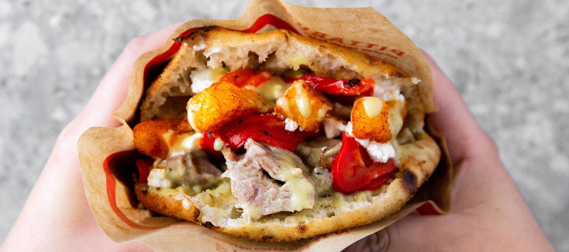 Sunday Roast PITTABUN with slow cooked lamb shoulder, feta cheese, roasted red peppers, lemon-oregano sauce